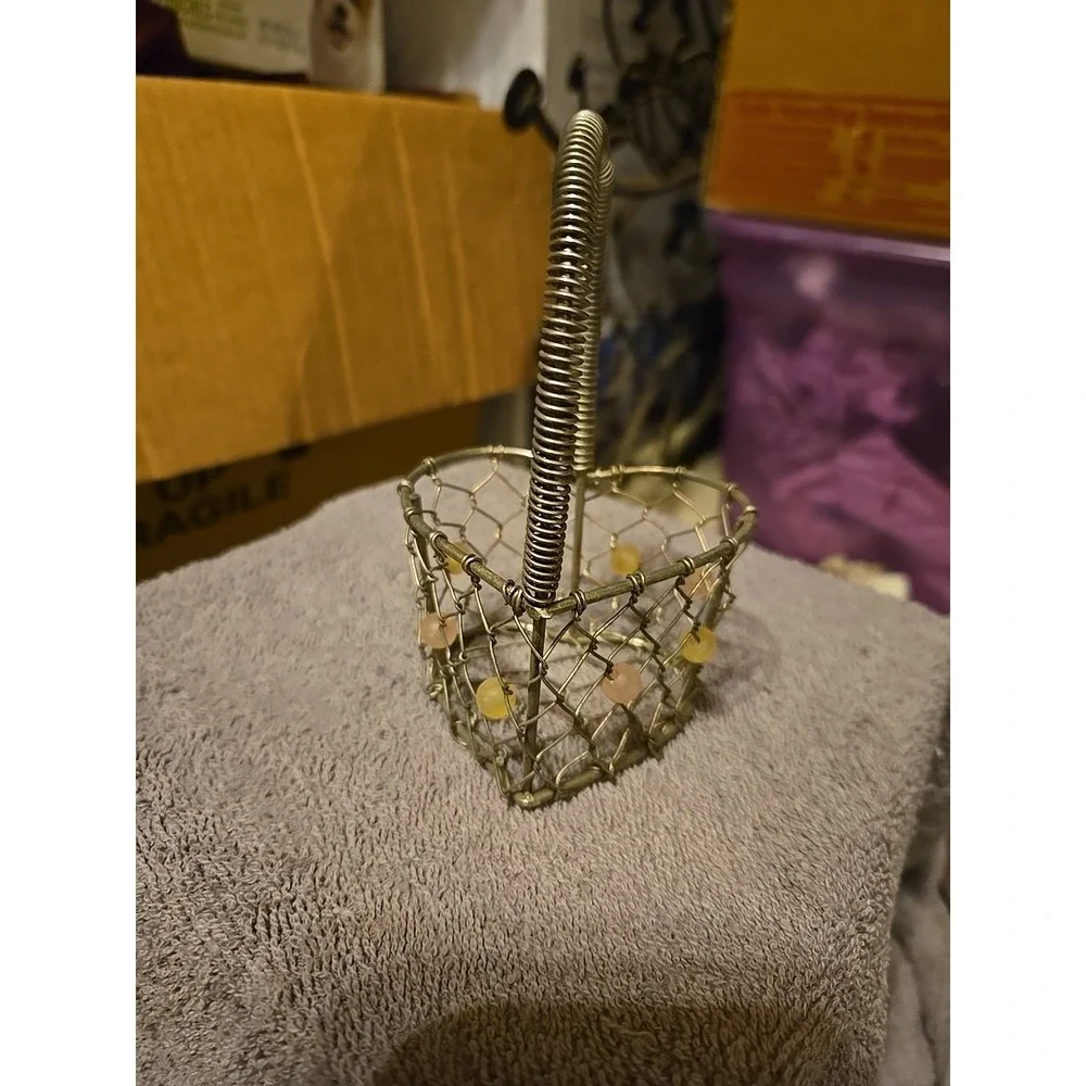 silver-tone wire basket featuring a heart-shaped base and a‎ coiled wire handle